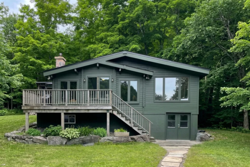 Modern house exterior painted in Sherwin-Williams Greenblack SW 6994 with natural warm wood accents